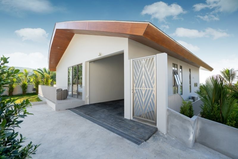 Modern home with a curved timber-lined carport roof over the driveway