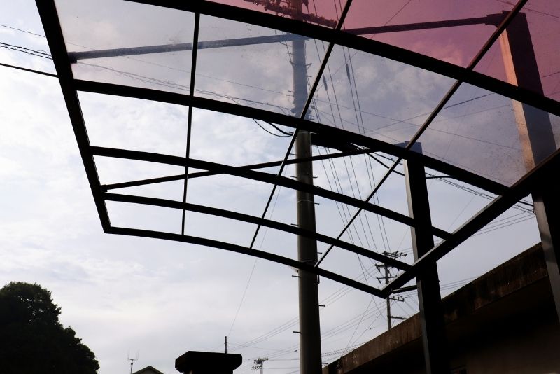 Curved carport roof structure supported by steel beams