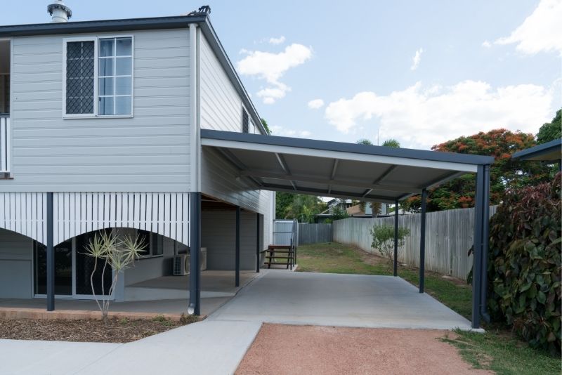 Steel carport attached beneath an elevated home