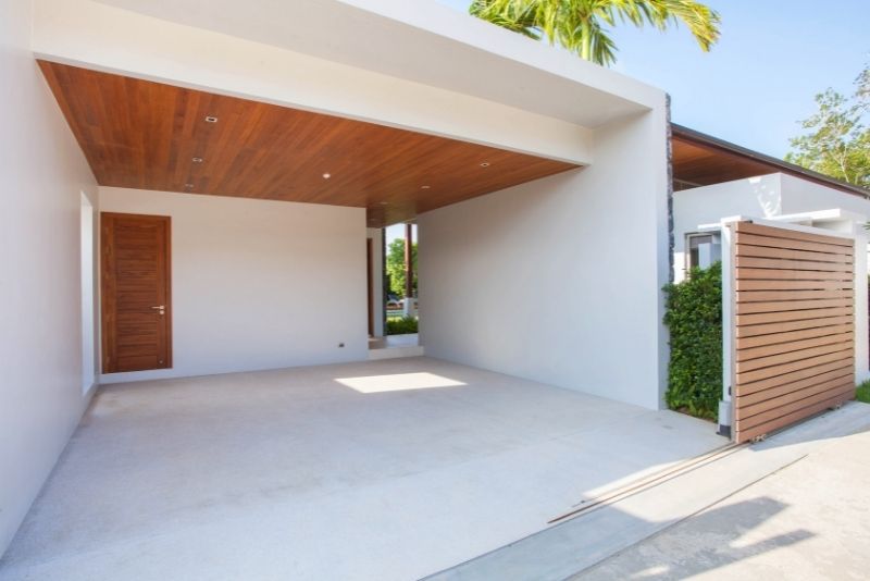 Open carport with a timber-lined ceiling attached to a modern home