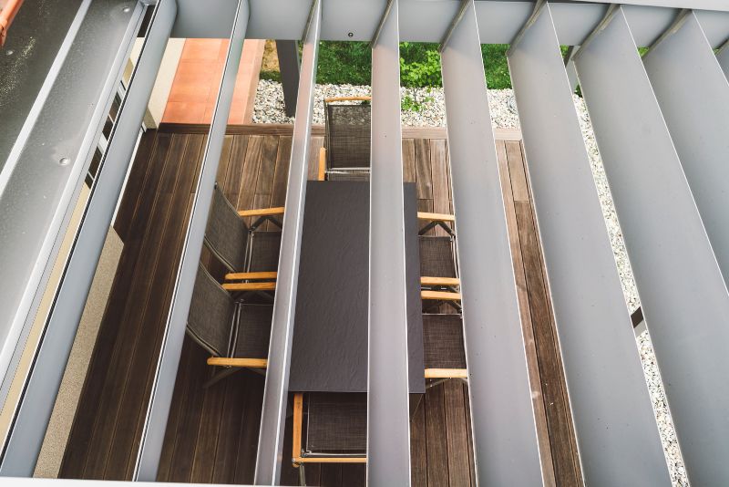 pergola roof dining table and chairs visible through it