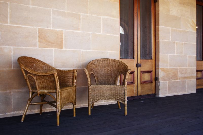 verandah in front of the door with two outdoor chairs